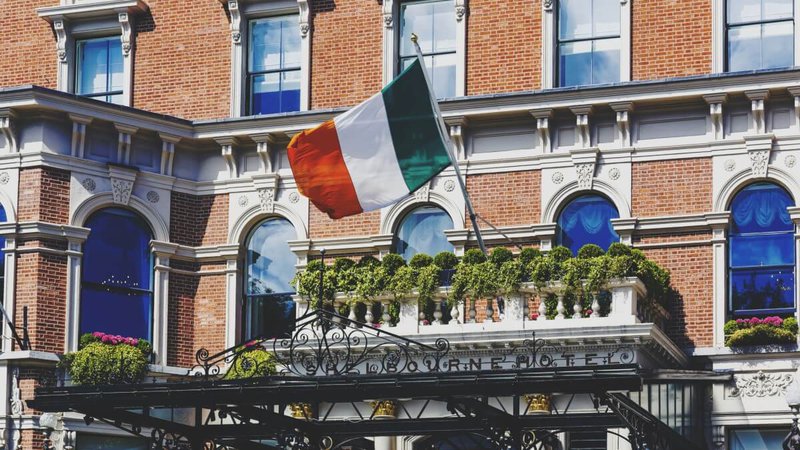 Irish flag waving from the Shelbourne Hotel`s entrance in Dublin, Ireland