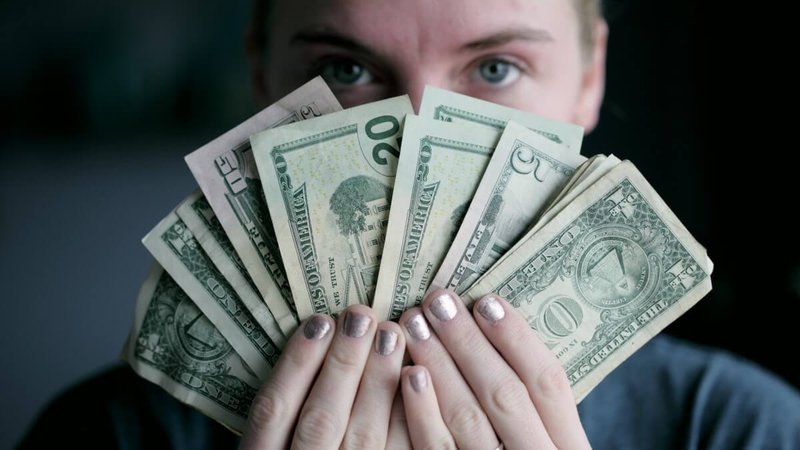 young girl holding dollars