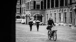 young woman riding a bike near Dutch Parliament, Netherlands